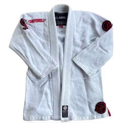 Shoyoroll Comp Standard XIV Q4 Gi in white, featuring a 450 GSM pearl weave jacket and 10-12 oz twill pants, displayed on a mannequin with minimalist "SGT." embroidery on the lapel.